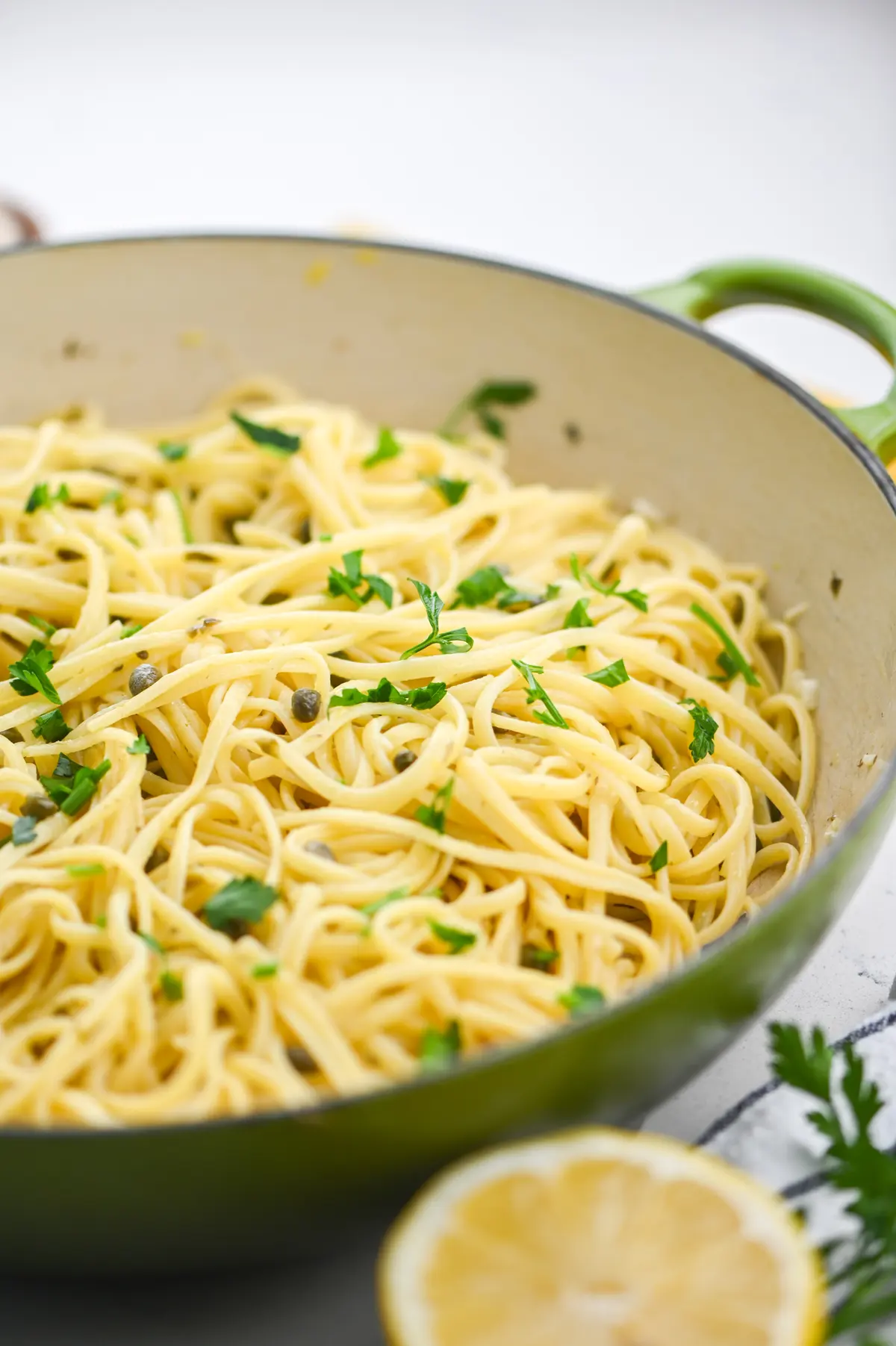 A bowl of lemon caper linguine with capers, lemon zest, and fresh parsley in a light butter sauce