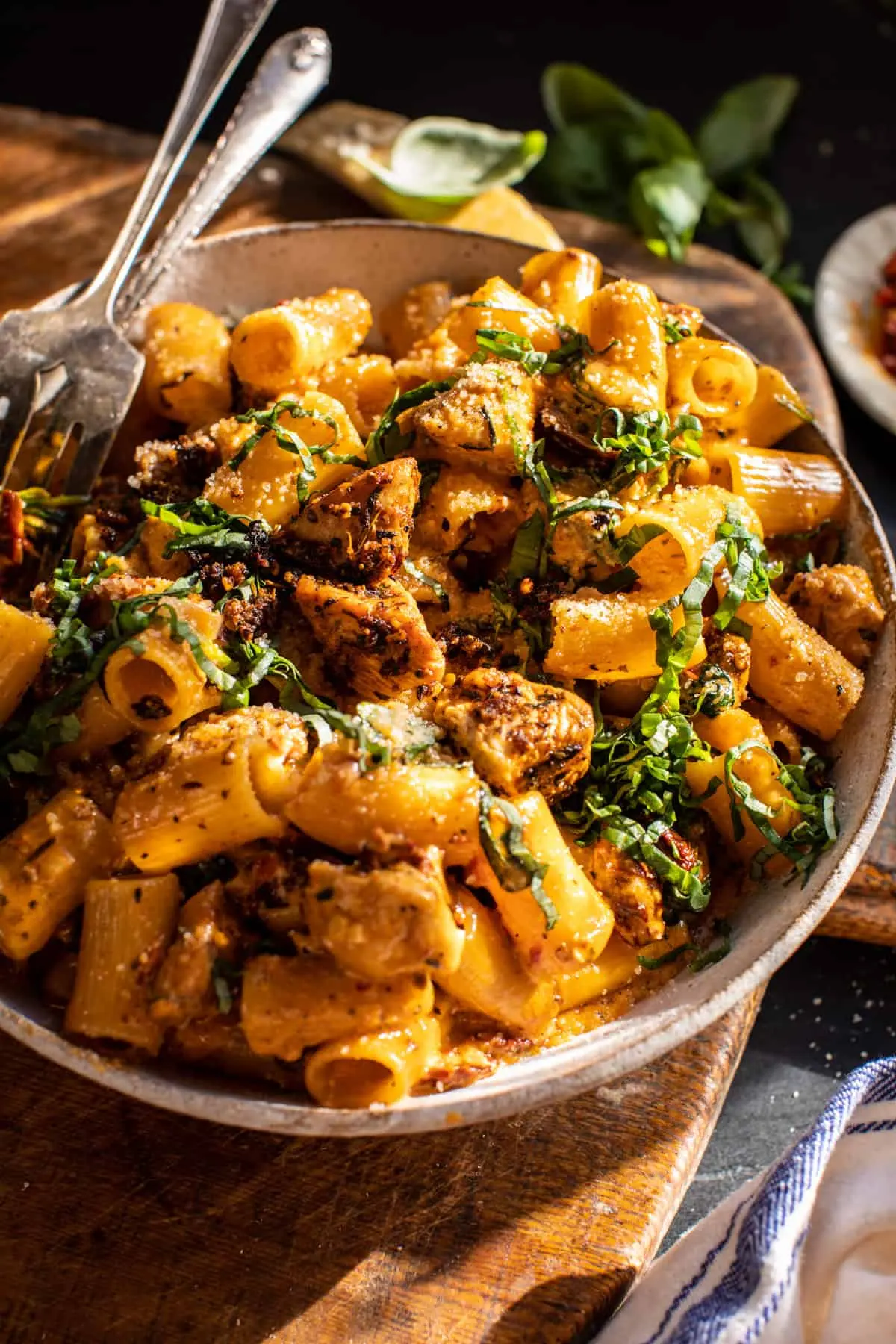 A creamy spicy Tuscan chicken pasta with sun-dried tomatoes, spinach, and parmesan in a cast iron skillet