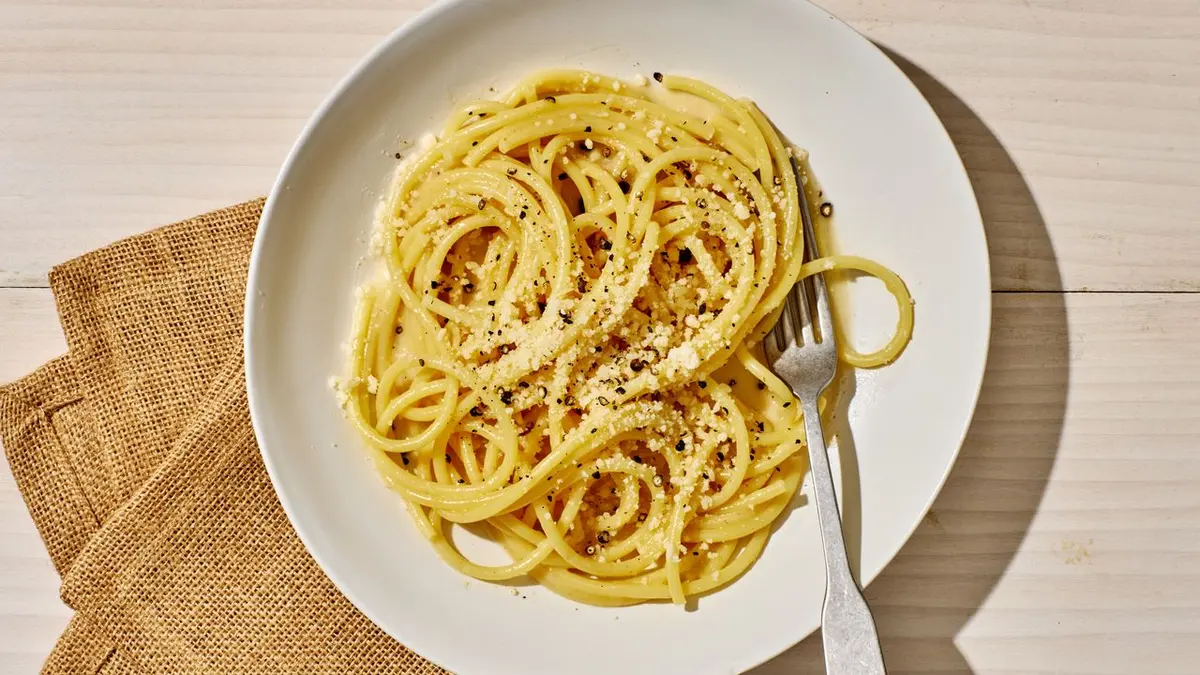 A bowl of cacio e pepe — spaghetti with pecorino romano sauce and cracked black pepper