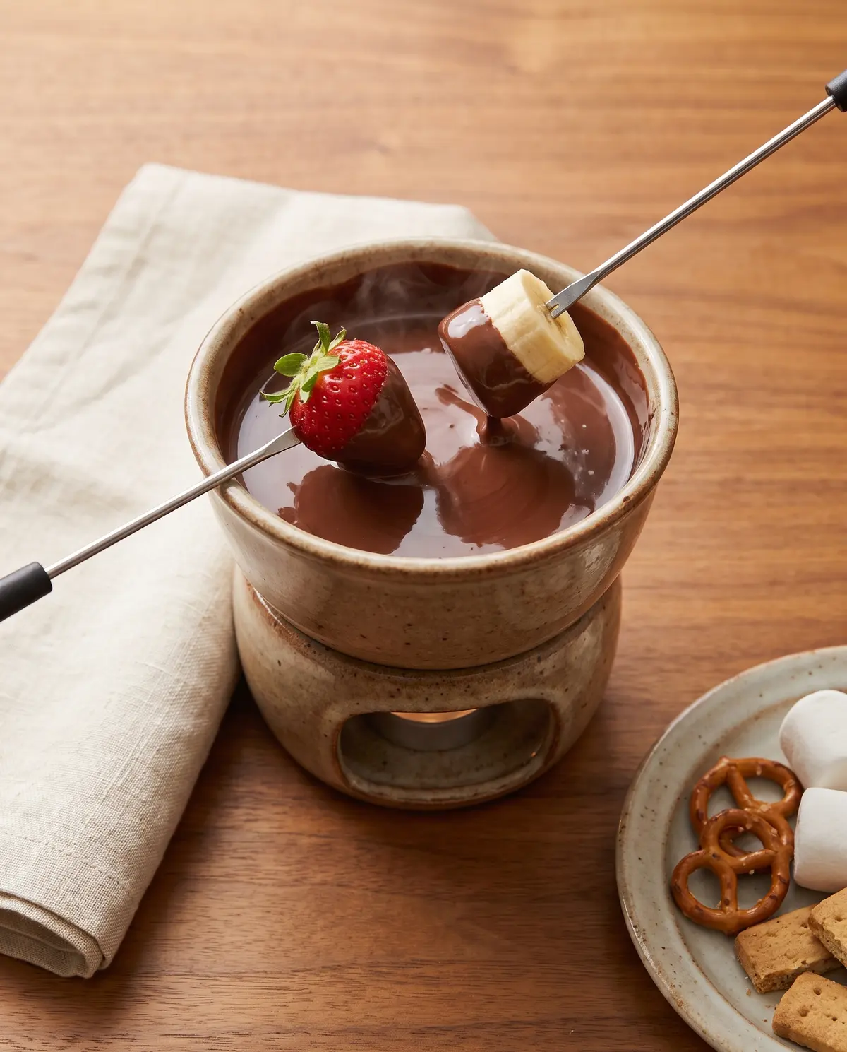 Chocolate fondue with strawberries and banana slices being dipped