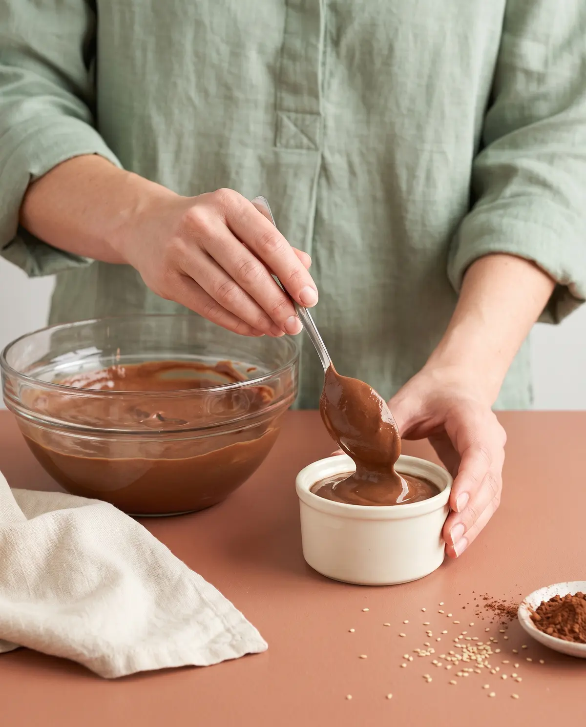 Spooning chocolate mousse into a small ceramic ramekin