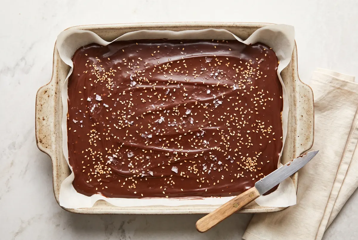 Whole uncut slab of chocolate tahini millionaire bites just out of the oven