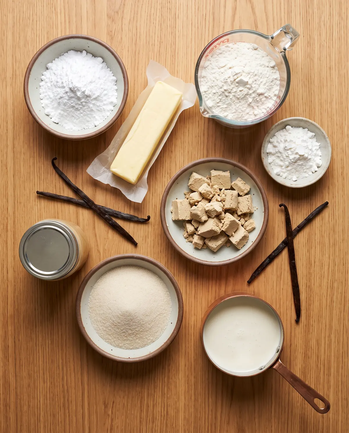 Ingredients for chocolate tahini millionaire shortbread arranged on a wood surface