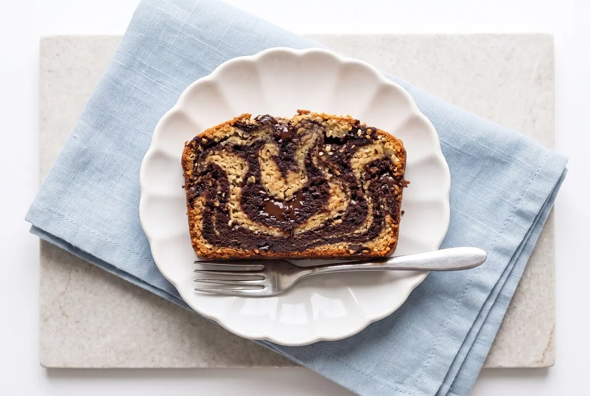A slice of chocolate tahini swirl loaf on a plate