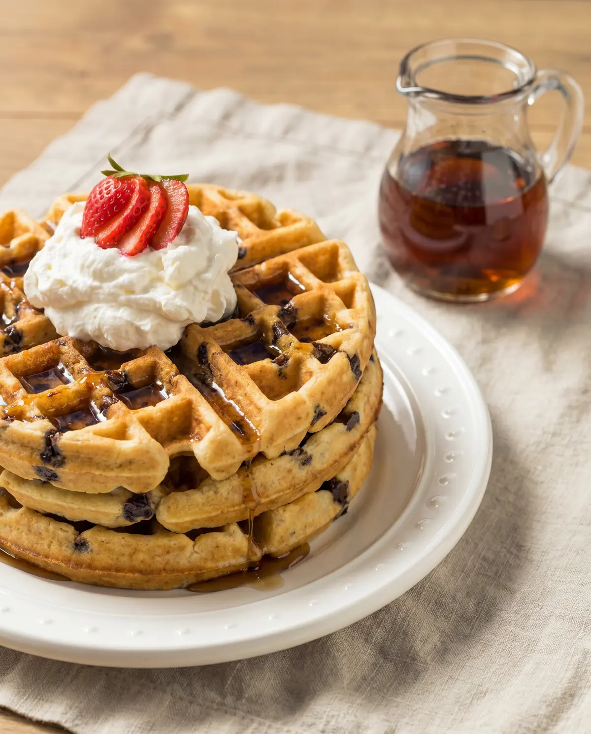 Waffles from 45-degree angle showing layers with syrup in pitcher